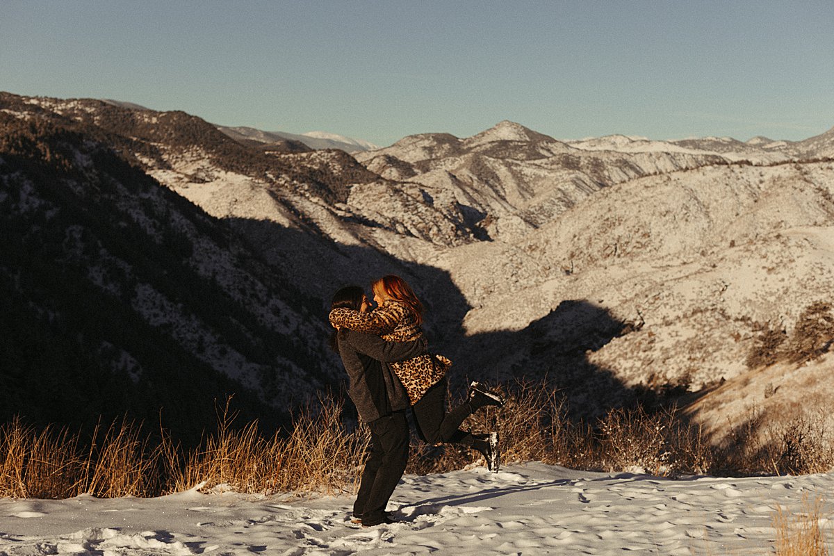 Couple engaged on Valentine's Day in Denver with mountain backdrop