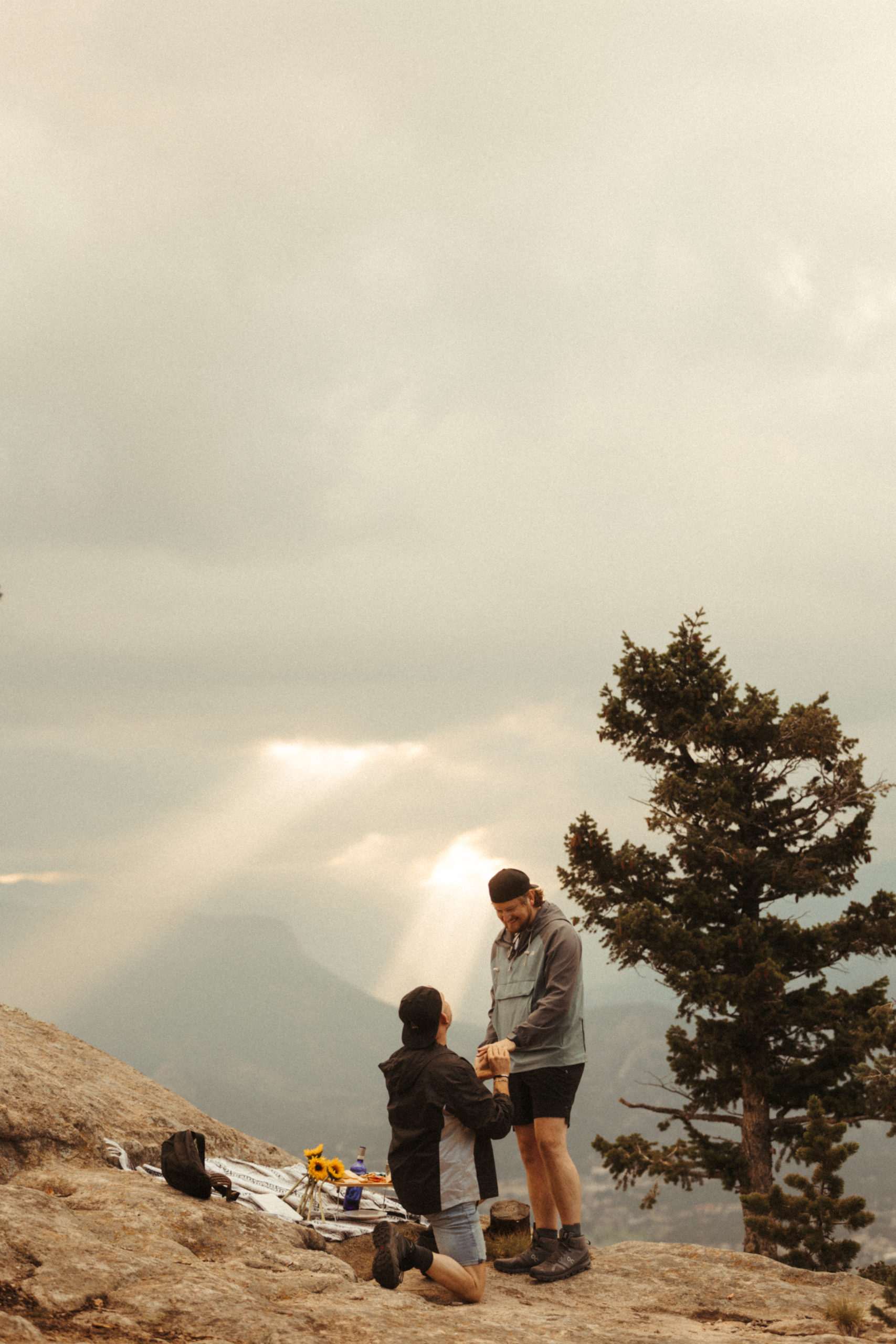 A man proposing to a man on top of a mountain