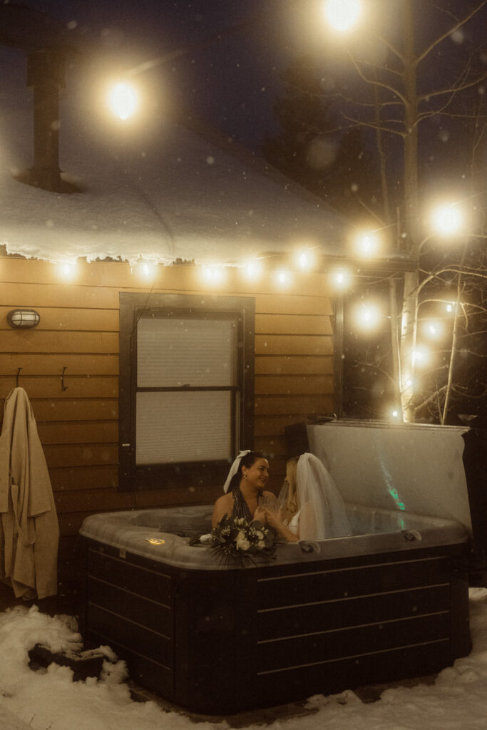 Two brides celebrating with a hot tub hangout at their Colorado Airbnb after they eloped.