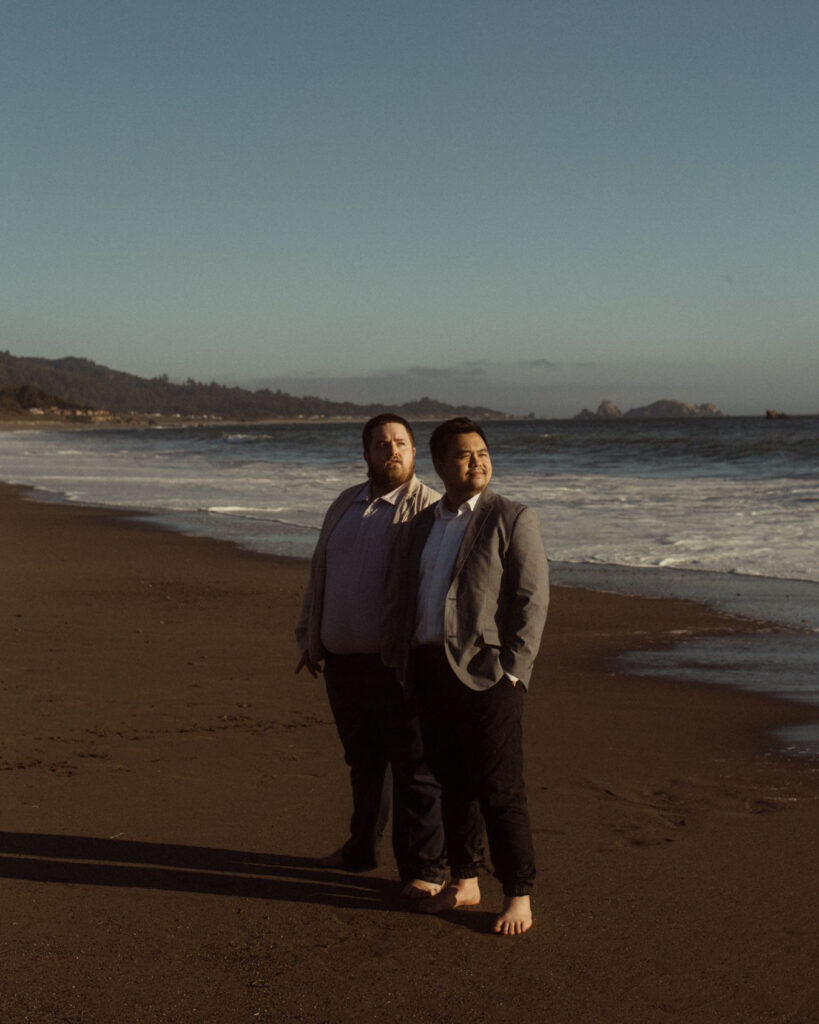 An LGBTQ couple who just eloped at Cannon Beach looking at the sunset