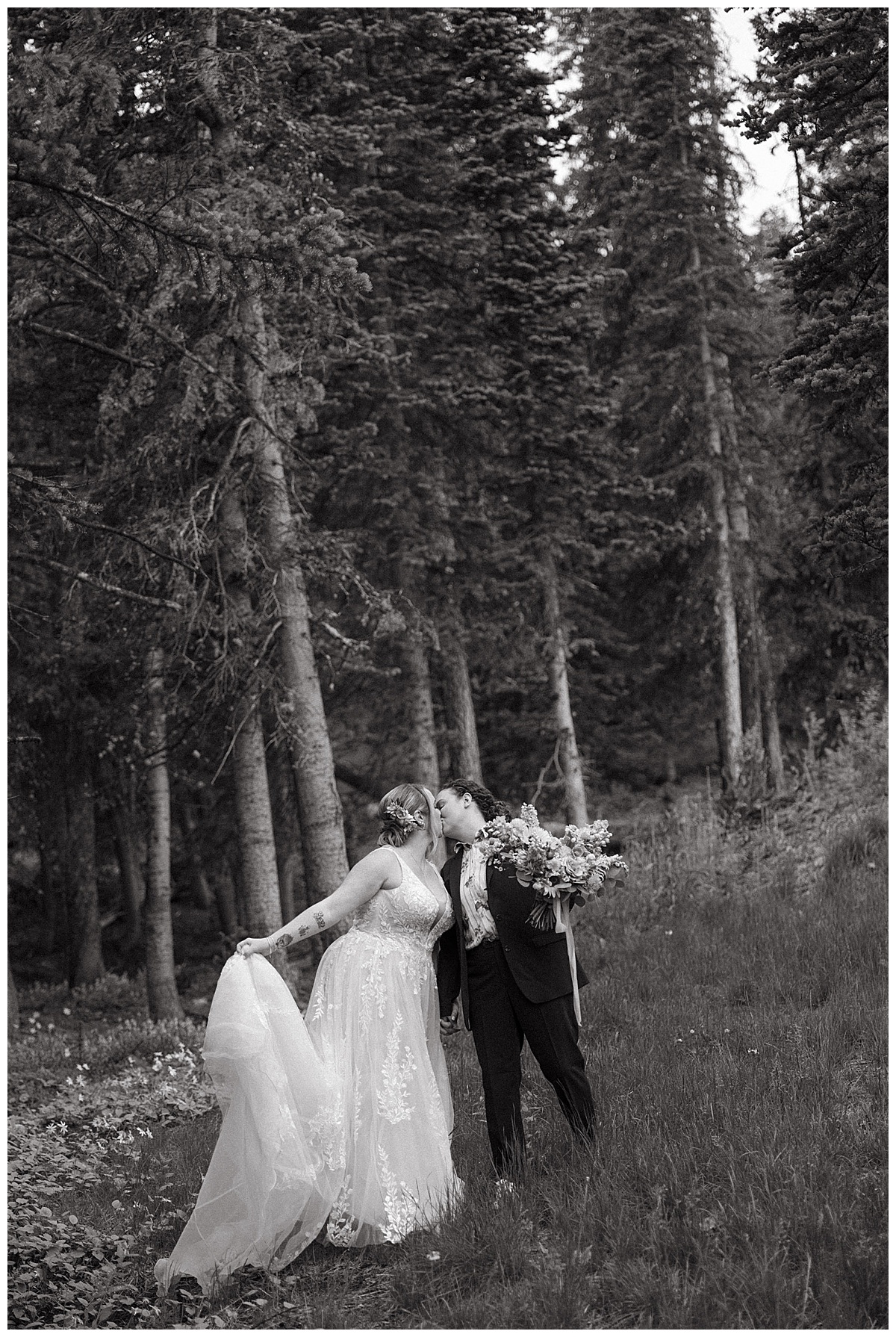 A couple shares a kiss during their sapphic mountain elopement.