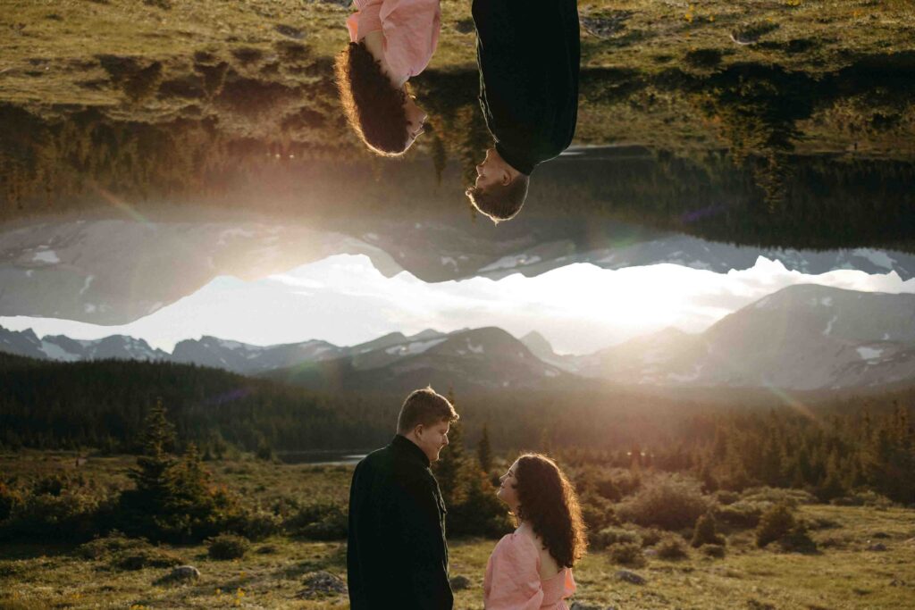 A mirrored image of a couple standing together watching the sunset over the mountains in Breckenridge Colorado. 